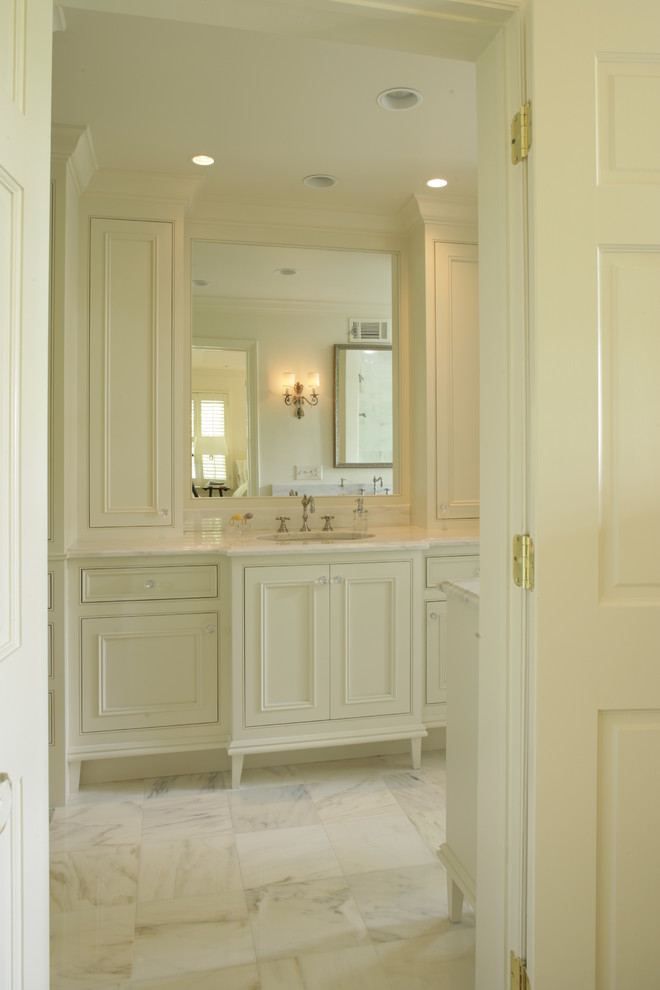 Idée de décoration pour une salle de bain tradition avec un lavabo encastré, un placard avec porte à panneau encastré, des portes de placard beiges et un carrelage blanc.