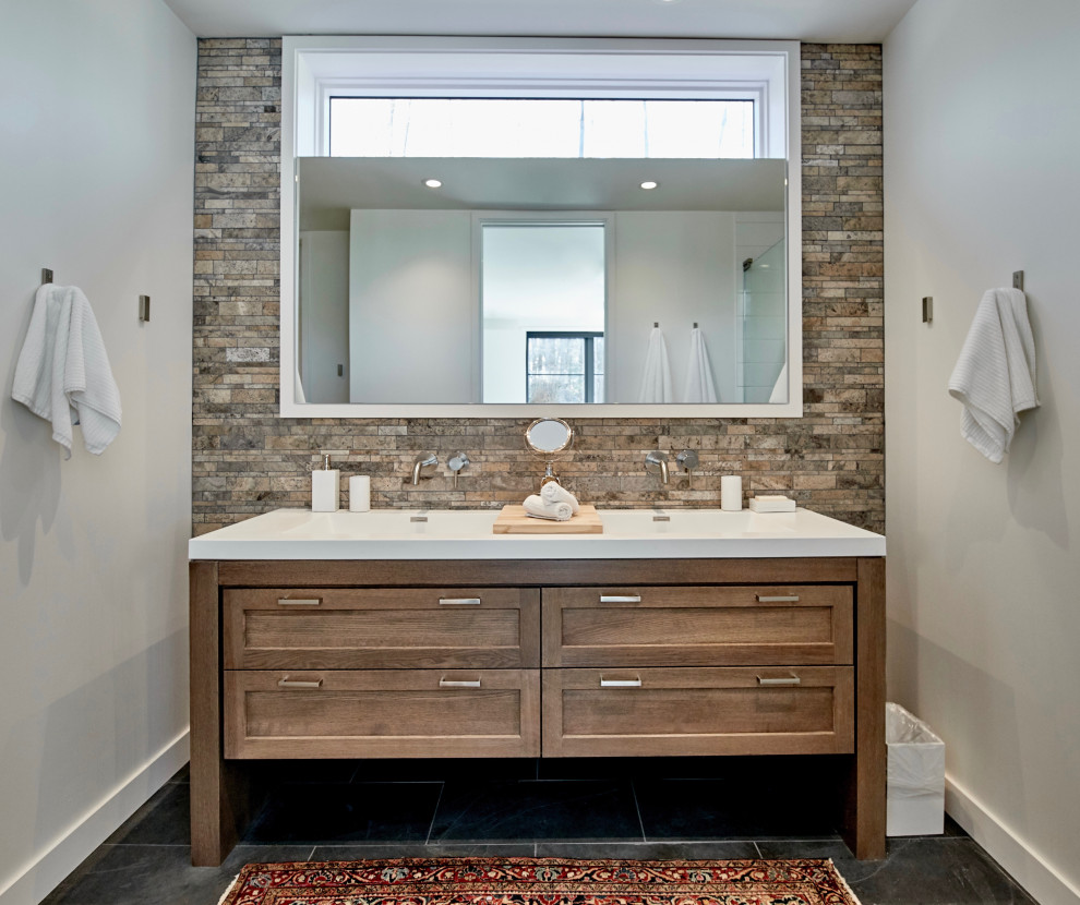 Inspiration for a medium sized rural ensuite bathroom in Chicago with shaker cabinets, medium wood cabinets, multi-coloured tiles, stone tiles, white walls, slate flooring, an integrated sink, solid surface worktops, grey floors, white worktops, a single sink and a freestanding vanity unit.