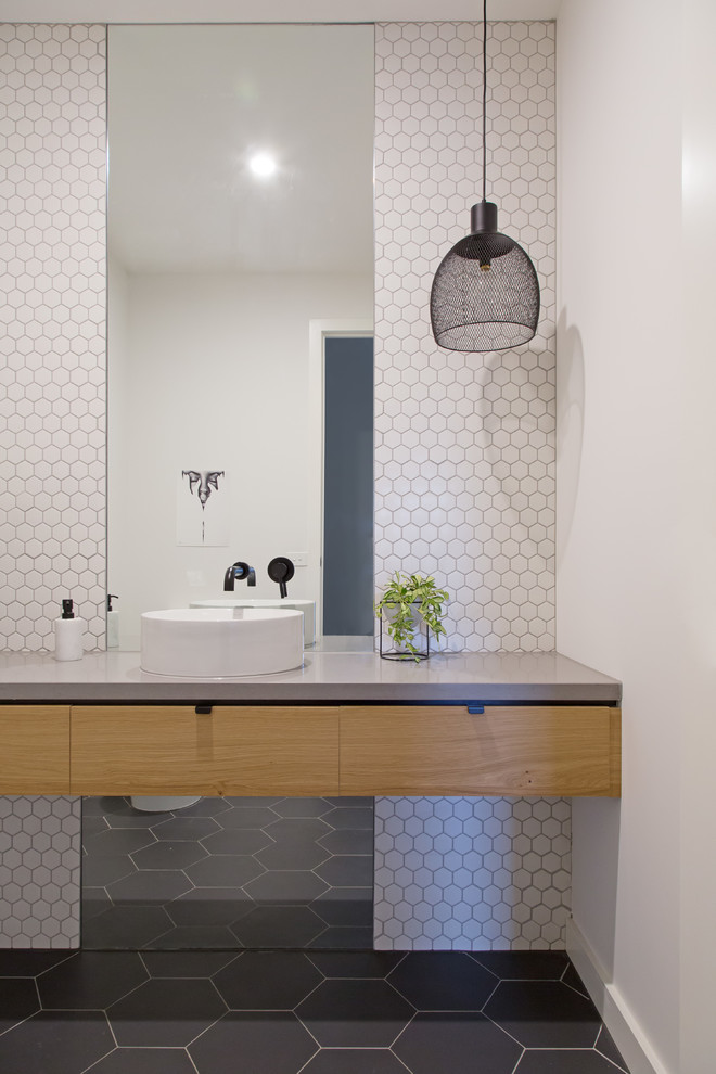 Design ideas for a medium sized contemporary ensuite bathroom in Melbourne with flat-panel cabinets, medium wood cabinets, grey tiles, white tiles, white walls, a vessel sink, a shower/bath combination, ceramic tiles, ceramic flooring, concrete worktops, grey floors and white worktops.