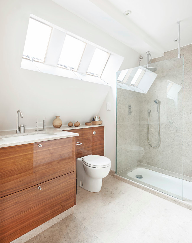 Идея дизайна: ванная комната в современном стиле с врезной раковиной, плоскими фасадами, фасадами цвета дерева среднего тона, душем в нише и серой плиткой