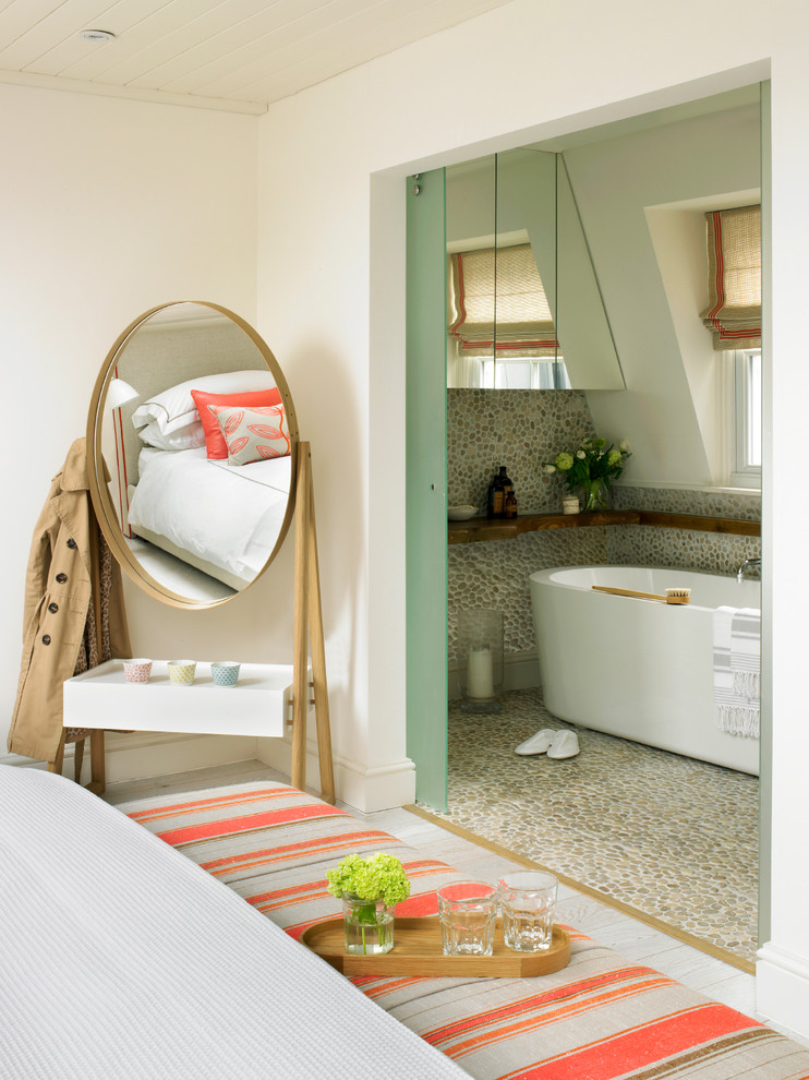 Modernes Badezimmer mit freistehender Badewanne, Kiesel-Bodenfliesen und Steinwänden in London