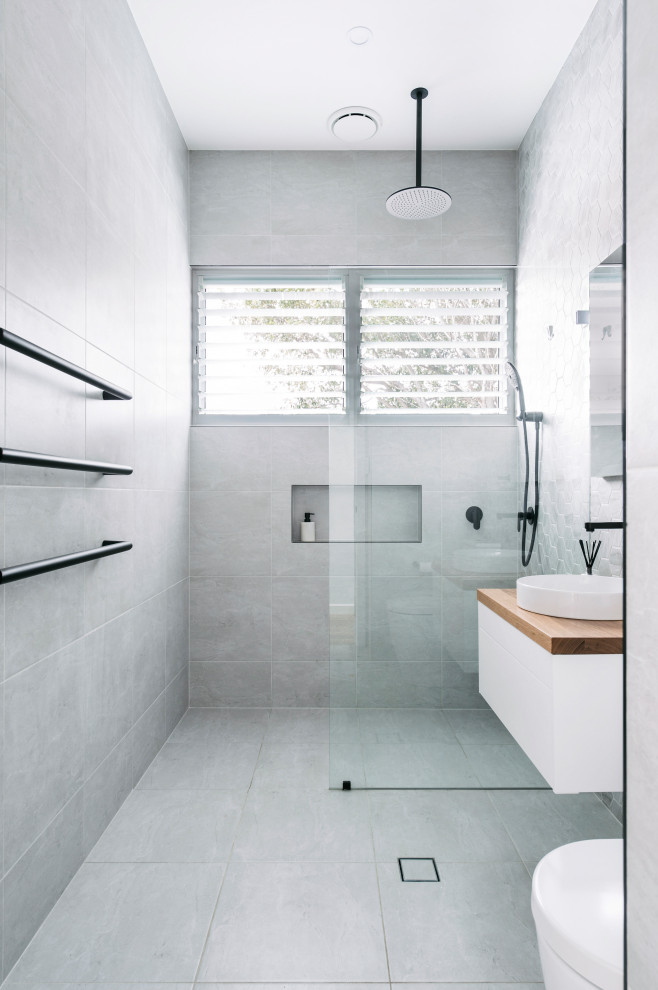 Inspiration for a mid-sized contemporary kids' gray tile and ceramic tile ceramic tile, green floor and single-sink bathroom remodel in Sydney with flat-panel cabinets, white cabinets, a wall-mount toilet, gray walls, a vessel sink, wood countertops, brown countertops, a niche and a floating vanity
