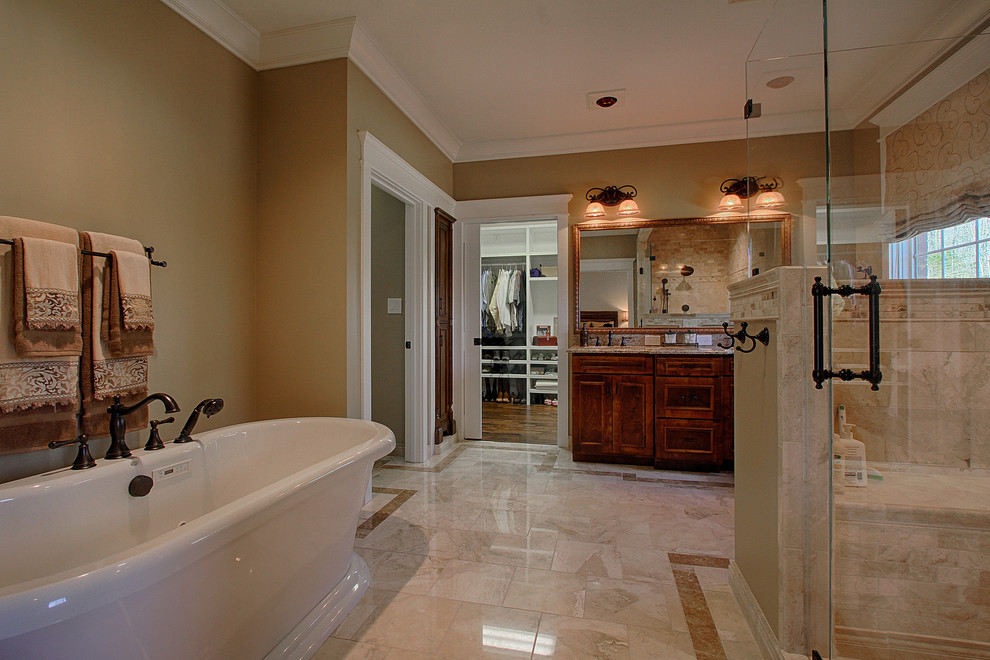 Bathroom - large traditional master beige tile and stone tile marble floor bathroom idea in Other with an undermount sink, raised-panel cabinets, dark wood cabinets, granite countertops and brown walls