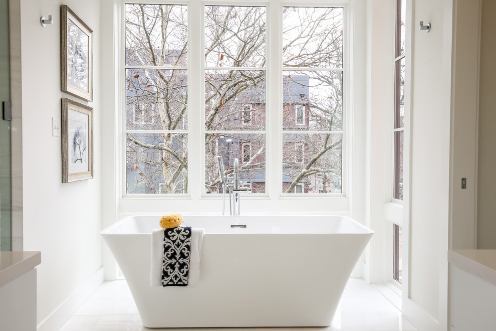На фото: главная ванная комната среднего размера в современном стиле с отдельно стоящей ванной, белыми стенами, полом из керамогранита и белым полом с