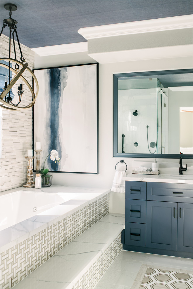 Corner shower - mid-sized transitional master marble tile marble floor and white floor corner shower idea in Orange County with shaker cabinets, blue cabinets, an undermount tub, gray walls, an undermount sink, quartz countertops, a hinged shower door and white countertops