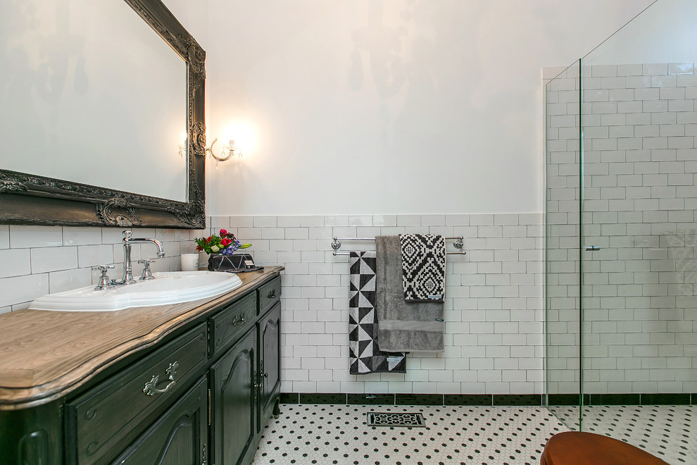 Shabby-Style Badezimmer mit integriertem Waschbecken, verzierten Schränken, Schränken im Used-Look, Waschtisch aus Holz, Duschnische, Wandtoilette mit Spülkasten, farbigen Fliesen, Porzellanfliesen, weißer Wandfarbe und Mosaik-Bodenfliesen in Melbourne