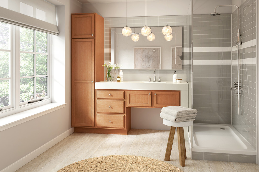 Photo of a medium sized traditional ensuite bathroom in Denver with recessed-panel cabinets, medium wood cabinets, a corner shower, grey tiles, metro tiles, white walls, laminate floors, an integrated sink, quartz worktops, beige floors and an open shower.