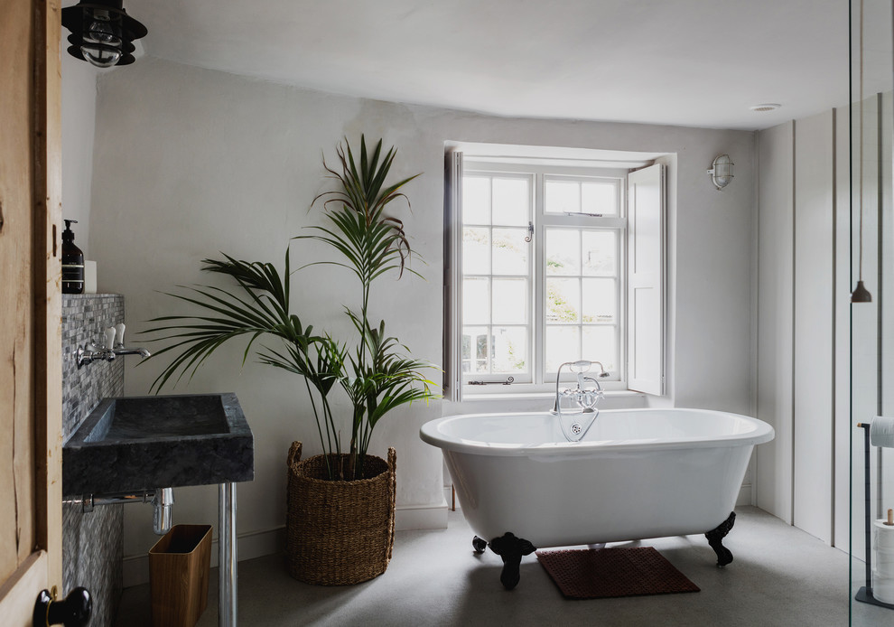 Aménagement d'une salle de bain principale classique de taille moyenne avec une baignoire sur pieds, un mur gris, un sol gris et un lavabo suspendu.