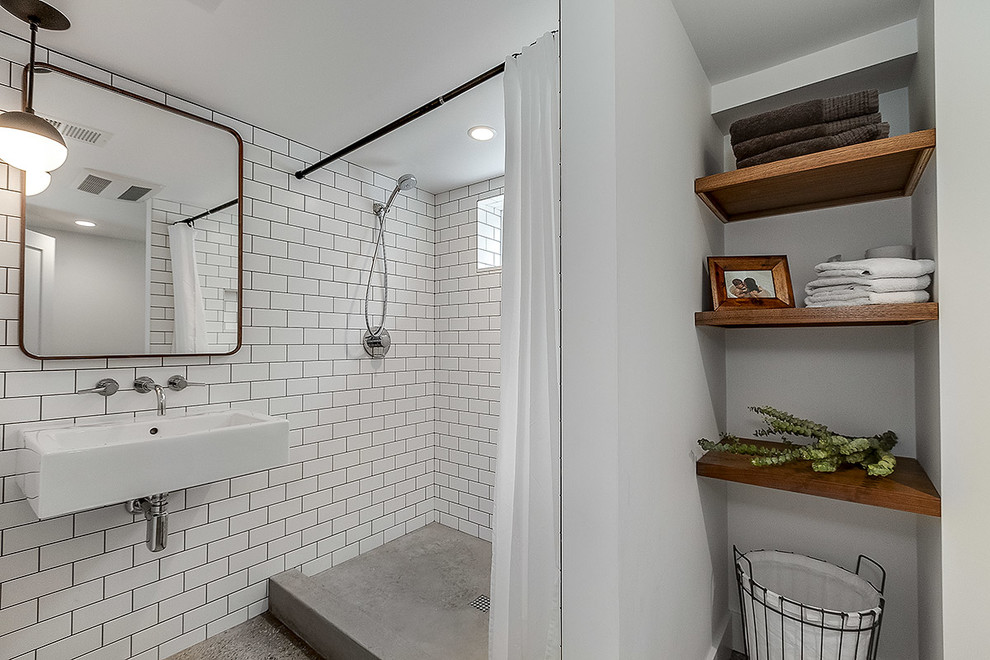 Idées déco pour une petite salle de bain industrielle avec un carrelage blanc, un carrelage métro, un mur blanc, sol en béton ciré, un lavabo suspendu, un sol marron et une cabine de douche avec un rideau.