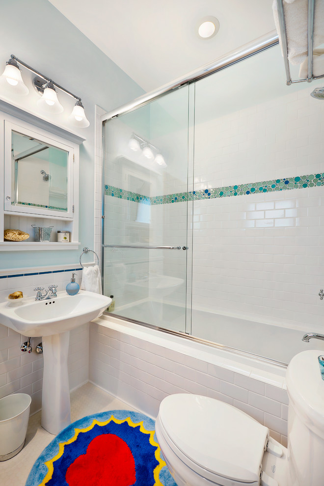 На фото: ванная комната в стиле кантри с раковиной с пьедесталом, ванной в нише, душем над ванной, раздельным унитазом, белой плиткой и керамической плиткой