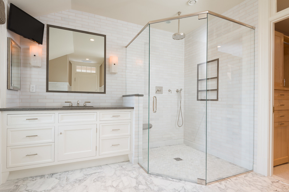 На фото: большая ванная комната в классическом стиле с врезной раковиной, белыми фасадами, угловым душем, белой плиткой, каменной плиткой, мраморным полом, фасадами с утопленной филенкой, душевой кабиной, белым полом и душем с распашными дверями