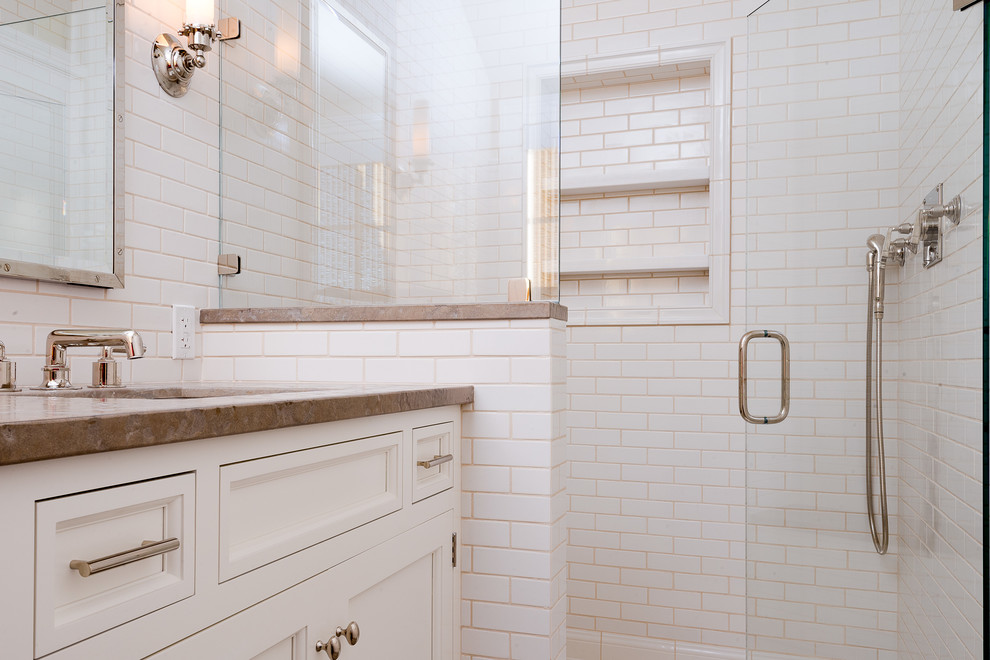Ispirazione per una stanza da bagno costiera con lavabo sottopiano, ante bianche, doccia alcova e piastrelle bianche