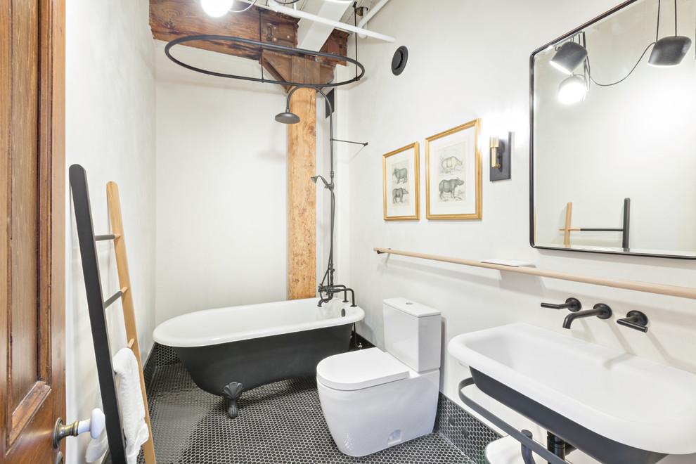 Medium sized urban ensuite bathroom in Toronto with a claw-foot bath, a shower/bath combination, a two-piece toilet, white walls, mosaic tile flooring, a wall-mounted sink and black floors.
