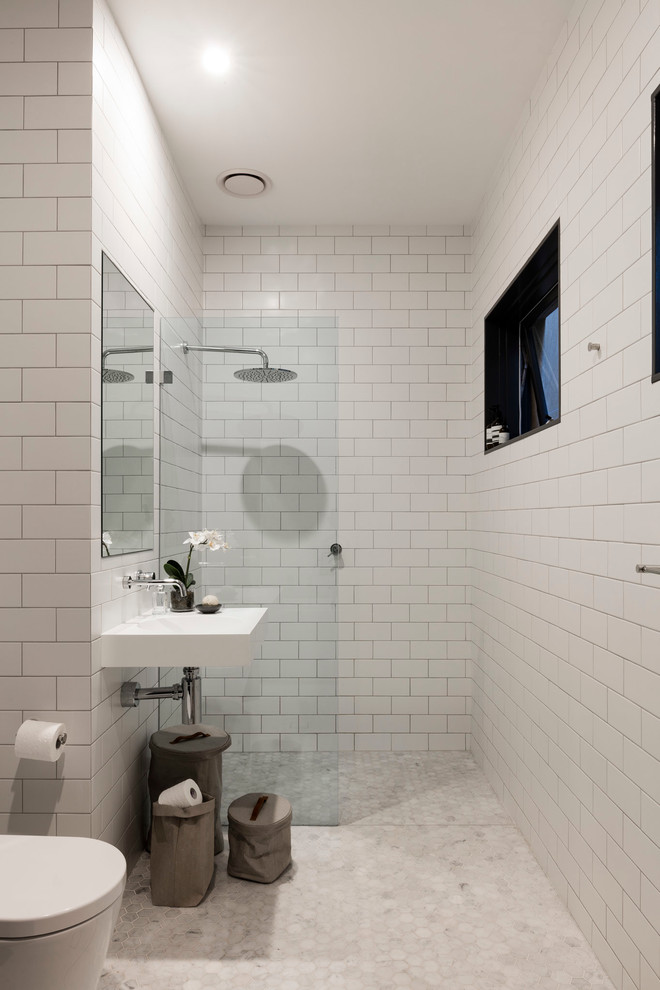 Immagine di una stanza da bagno con doccia minimal di medie dimensioni con nessun'anta, doccia aperta, WC monopezzo, piastrelle bianche, piastrelle diamantate, pareti bianche, pavimento in marmo, lavabo sospeso e top in superficie solida
