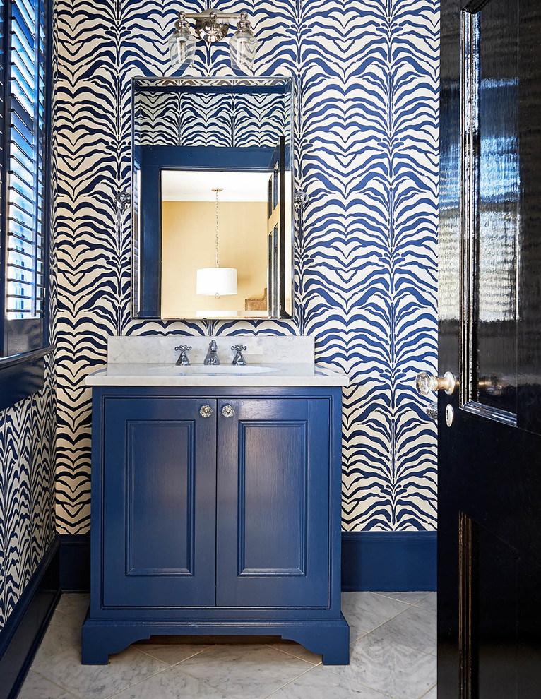 Diseño de cuarto de baño clásico con lavabo tipo consola, puertas de armario azules, paredes multicolor y armarios con paneles empotrados