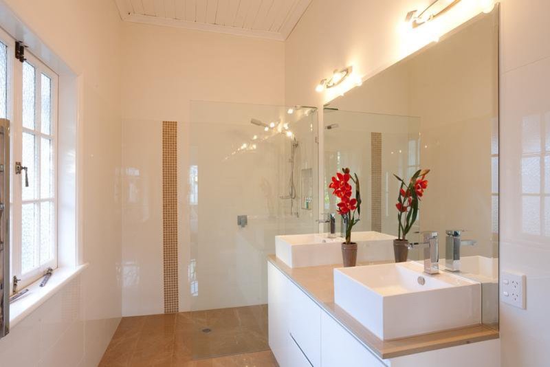 Esempio di una stanza da bagno padronale country di medie dimensioni con ante lisce, ante bianche, top in granito, doccia aperta, piastrelle marroni e piastrelle in pietra