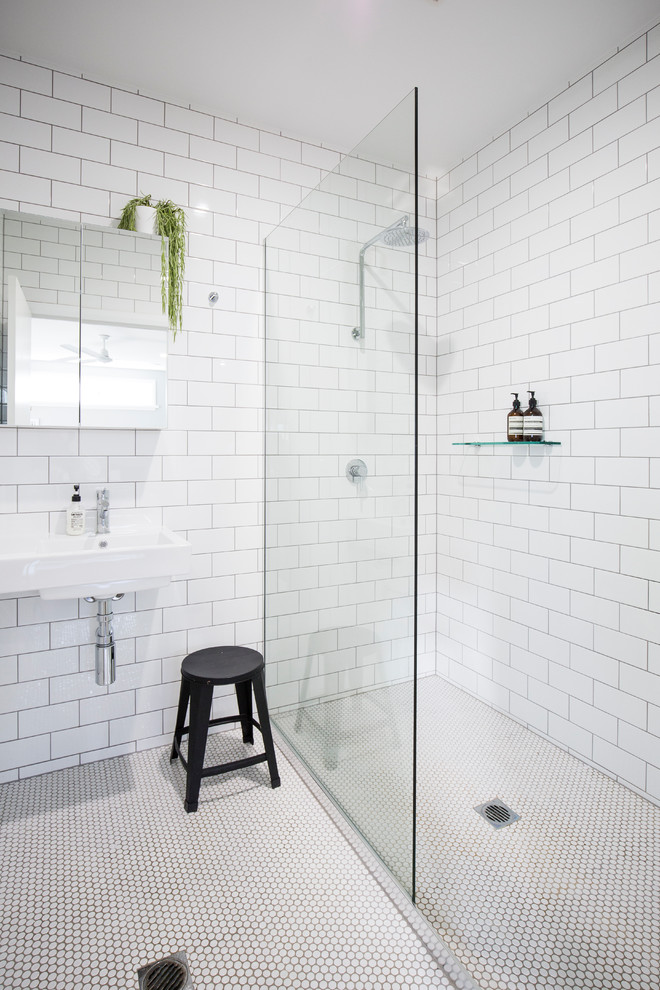 Cette photo montre une salle d'eau tendance de taille moyenne avec une douche ouverte, un carrelage blanc, un carrelage métro, un mur blanc, un sol en carrelage de terre cuite, un lavabo suspendu et aucune cabine.