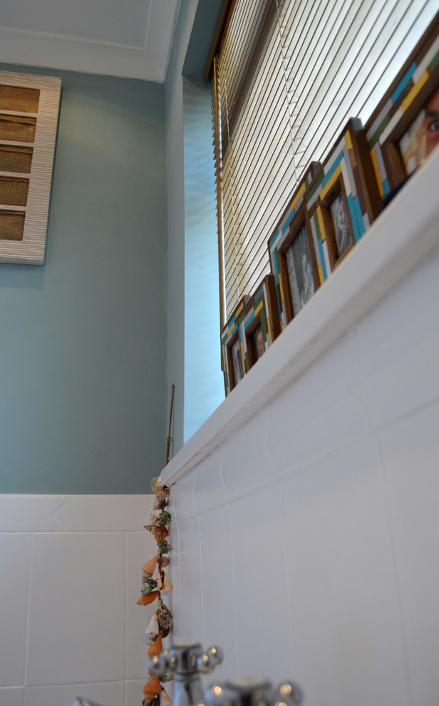 Diseño de cuarto de baño infantil costero pequeño con sanitario de una pieza, paredes azules y suelo de linóleo