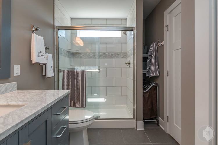 Example of an arts and crafts master gray tile and porcelain tile ceramic tile double shower design in Grand Rapids with furniture-like cabinets, gray cabinets, a one-piece toilet, gray walls, a drop-in sink and marble countertops