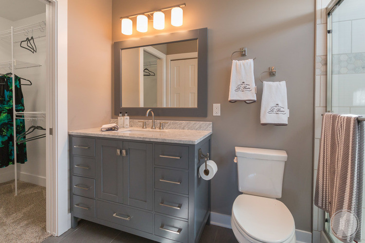 Mid-sized arts and crafts master gray tile and ceramic tile ceramic tile doorless shower photo in Grand Rapids with furniture-like cabinets, gray cabinets, a two-piece toilet, gray walls, a drop-in sink and marble countertops