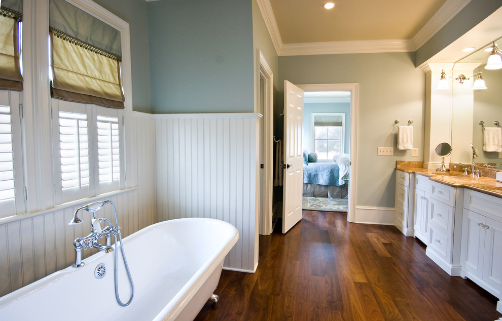Example of a classic dark wood floor and brown floor claw-foot bathtub design in Charleston