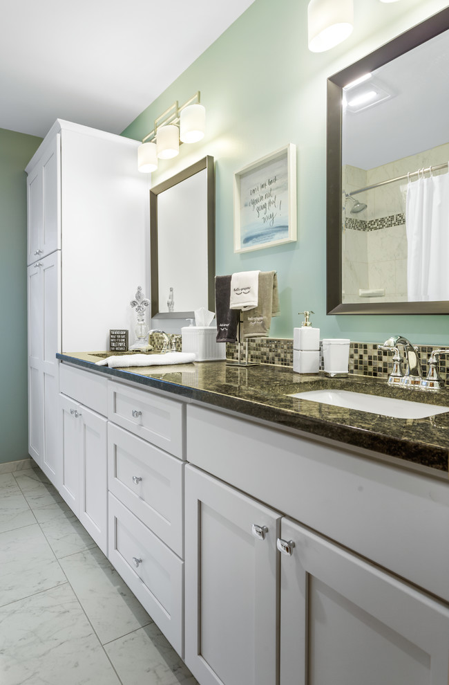 Photo of a medium sized modern shower room bathroom in Chicago with shaker cabinets, white cabinets, an alcove bath, a two-piece toilet, black and white tiles, blue walls, a built-in sink, white floors and black worktops.