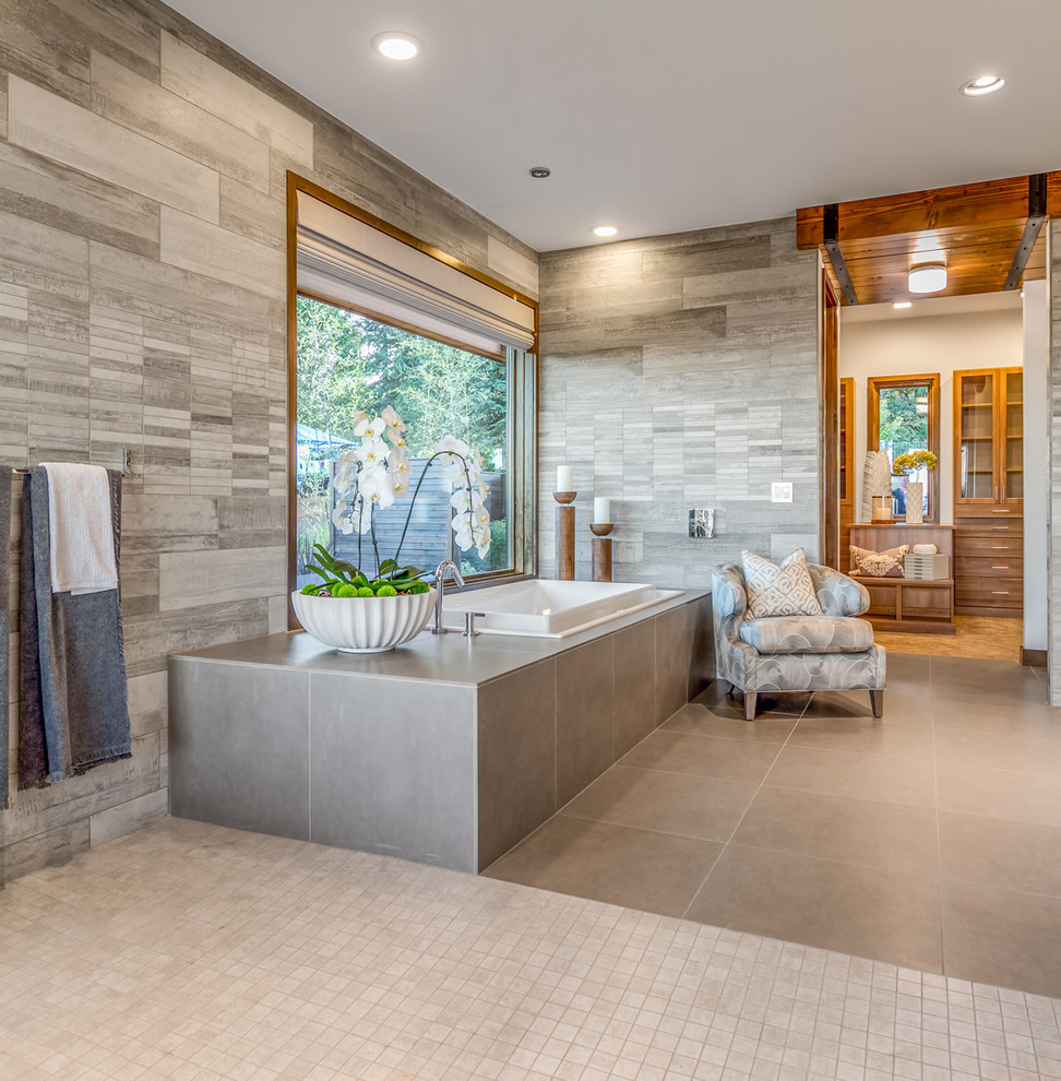 Ispirazione per una stanza da bagno padronale design con vasca da incasso, piastrelle grigie e pareti grigie