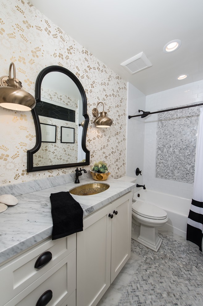 This is an example of a medium sized traditional bathroom in San Diego with a submerged sink, shaker cabinets, white cabinets, marble worktops, a built-in bath, a shower/bath combination, a one-piece toilet, multi-coloured tiles, ceramic tiles, multi-coloured walls and marble flooring.