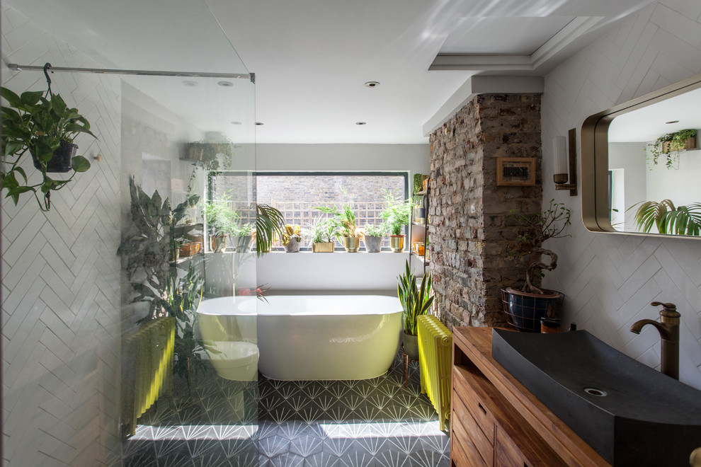 ロンドンにあるコンテンポラリースタイルのおしゃれな浴室 (中間色木目調キャビネット、置き型浴槽、白いタイル、白い壁、ベッセル式洗面器、木製洗面台、グレーの床、ブラウンの洗面カウンター、フラットパネル扉のキャビネット) の写真