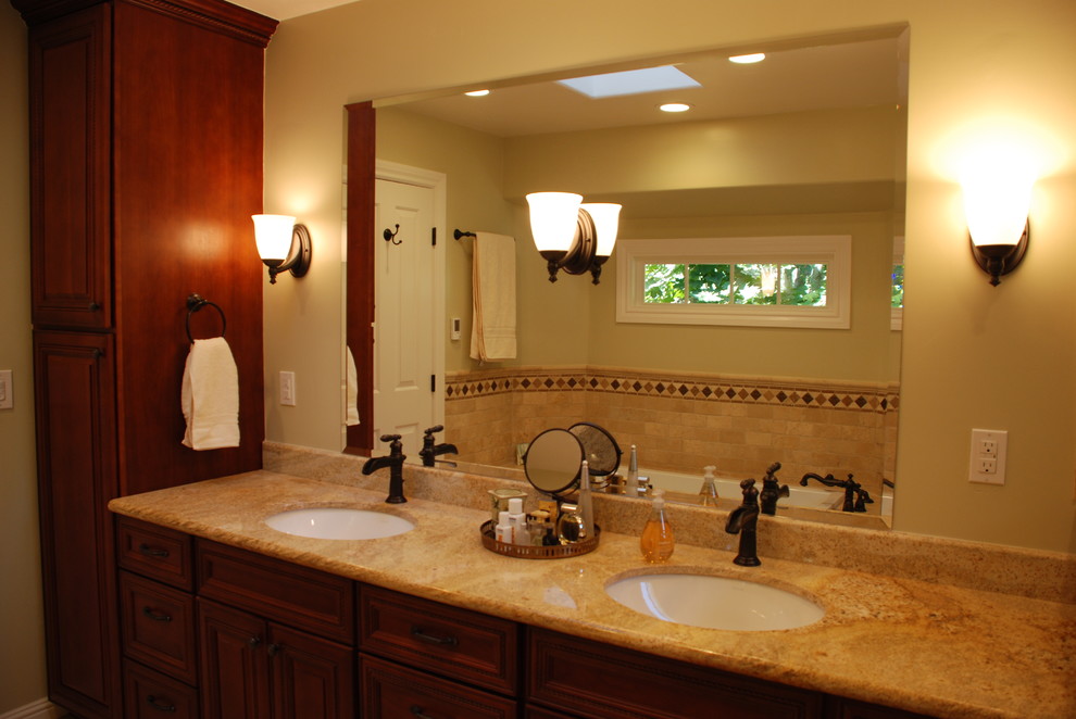 Mid-sized tuscan master beige tile and stone tile ceramic tile bathroom photo in San Francisco with an undermount sink, raised-panel cabinets, dark wood cabinets, granite countertops, a two-piece toilet and green walls