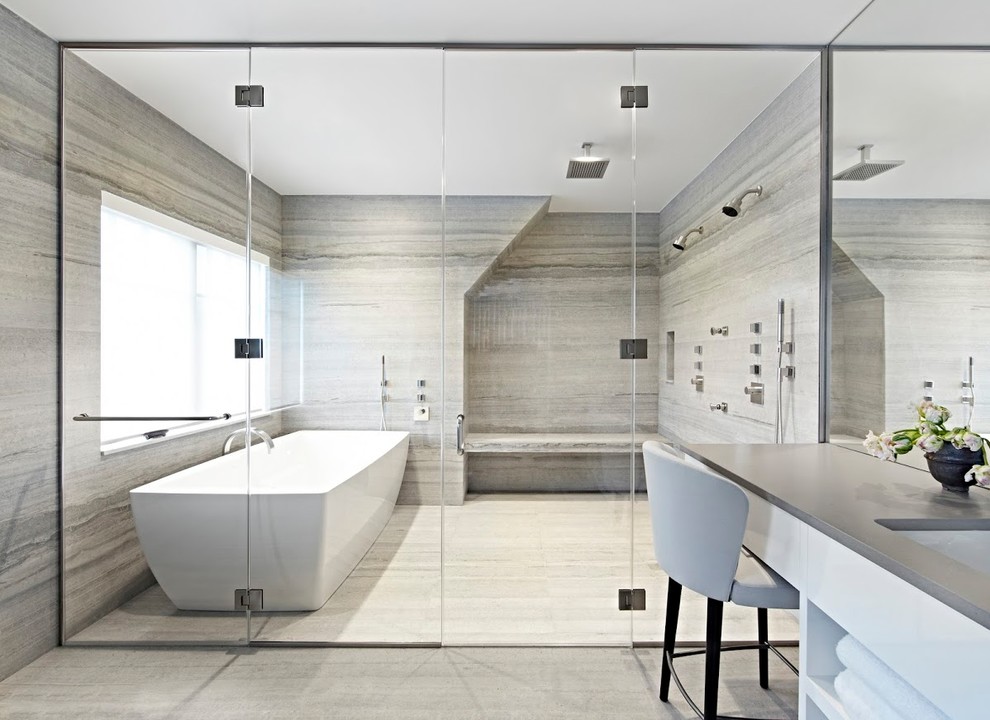 Exemple d'une grande salle de bain principale moderne avec des portes de placard blanches, une baignoire indépendante, une douche à l'italienne, un carrelage gris, un mur gris, un lavabo encastré, un plan de toilette en surface solide, un sol gris, une cabine de douche à porte battante et un plan de toilette gris.