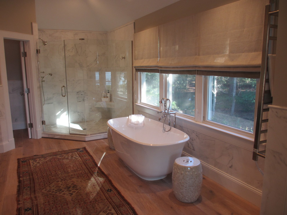 Exemple d'une salle de bain chic avec une baignoire indépendante, une douche d'angle et parquet clair.