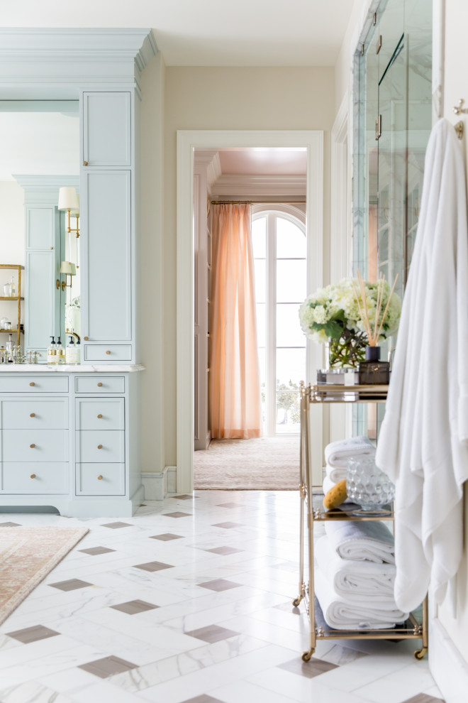 Источник вдохновения для домашнего уюта: большая главная ванная комната в классическом стиле с фасадами островного типа, синими фасадами, отдельно стоящей ванной, двойным душем, раздельным унитазом, розовыми стенами, врезной раковиной, мраморной столешницей, душем с распашными дверями и белой столешницей