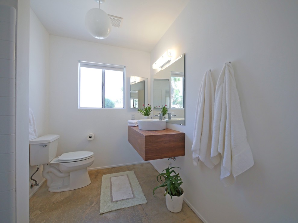 Kleines Retro Badezimmer mit hellbraunen Holzschränken, weißer Wandfarbe, Betonboden, Wandwaschbecken und Waschtisch aus Holz in Los Angeles