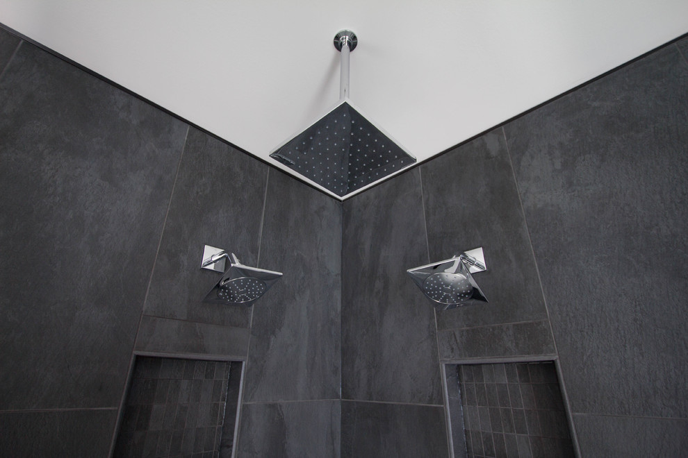 Стильный дизайн: главная ванная комната среднего размера в стиле модернизм с плоскими фасадами, черными фасадами, накладной ванной, угловым душем, черной плиткой, керамогранитной плиткой, серыми стенами, полом из керамогранита, монолитной раковиной, столешницей из искусственного камня, белым полом и душем с распашными дверями - последний тренд