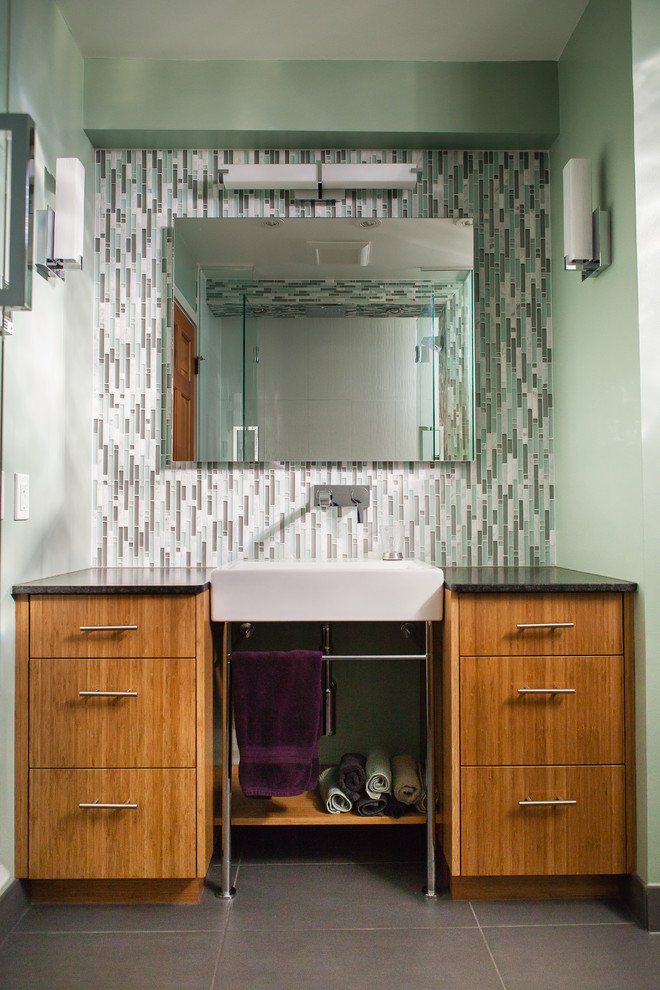 Réalisation d'une salle de bain principale design en bois brun de taille moyenne avec une baignoire d'angle, un combiné douche/baignoire, un carrelage multicolore, un carrelage en pâte de verre, un mur vert, un sol en carrelage de porcelaine, une vasque et un plan de toilette en granite.