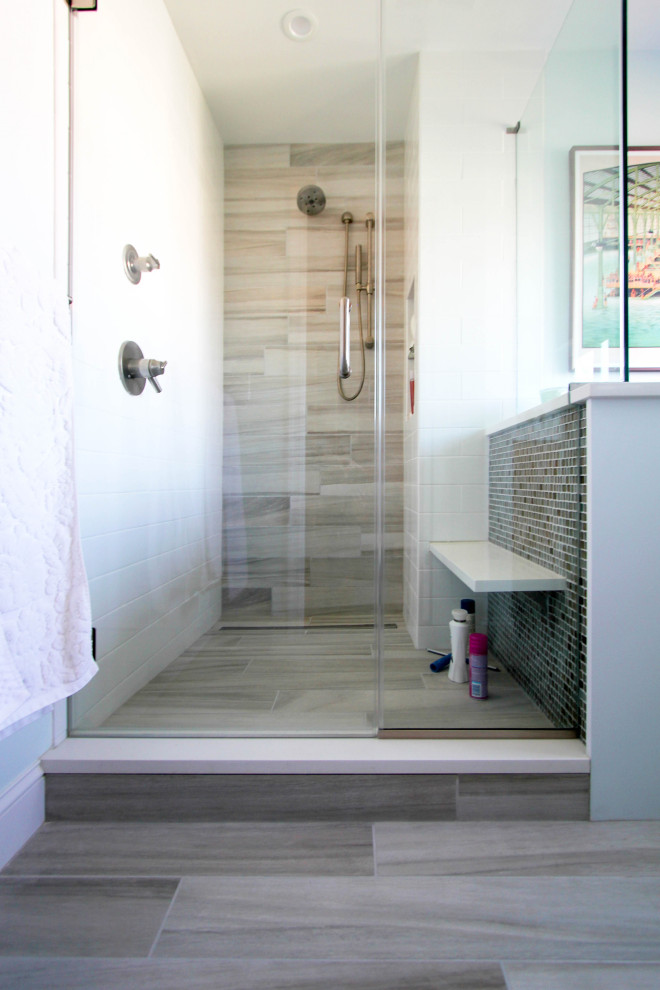Example of a mid-sized minimalist master multicolored tile and glass tile terra-cotta tile and gray floor corner shower design in Philadelphia with flat-panel cabinets, medium tone wood cabinets, a hinged shower door, white countertops, an undermount sink, a two-piece toilet, white walls and quartz countertops