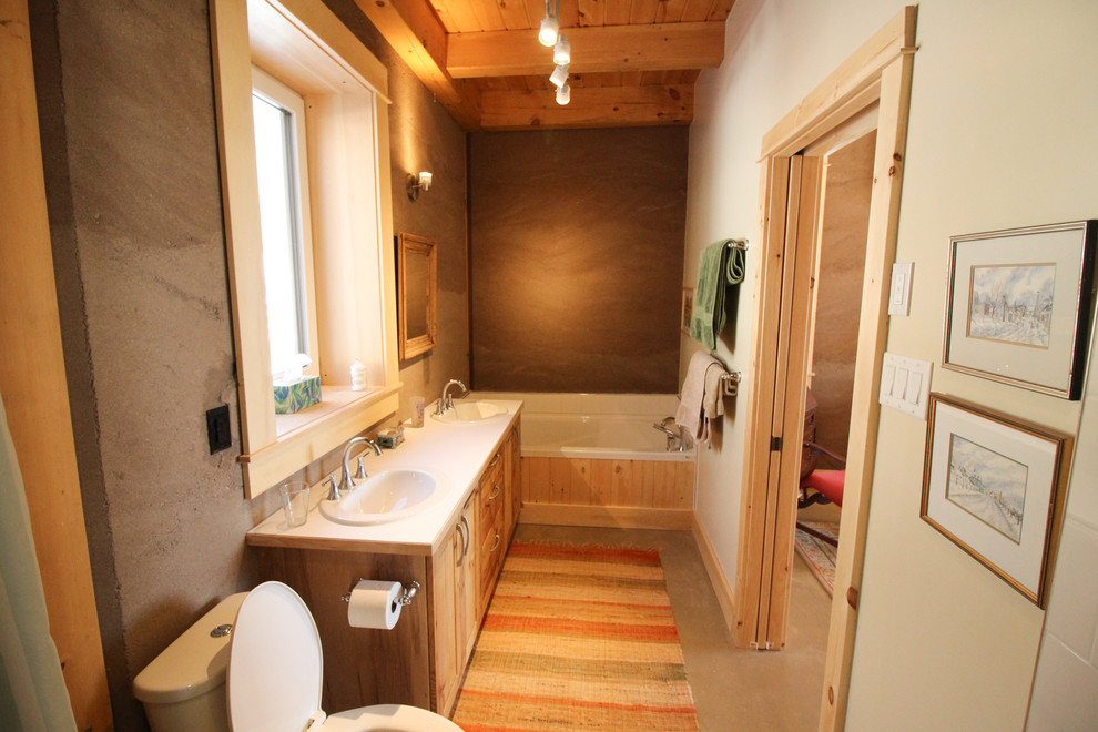 Imagen de cuarto de baño principal de estilo americano de tamaño medio con armarios tipo mueble, puertas de armario de madera oscura, bañera esquinera, ducha abierta, sanitario de una pieza, paredes marrones, suelo de cemento y lavabo encastrado