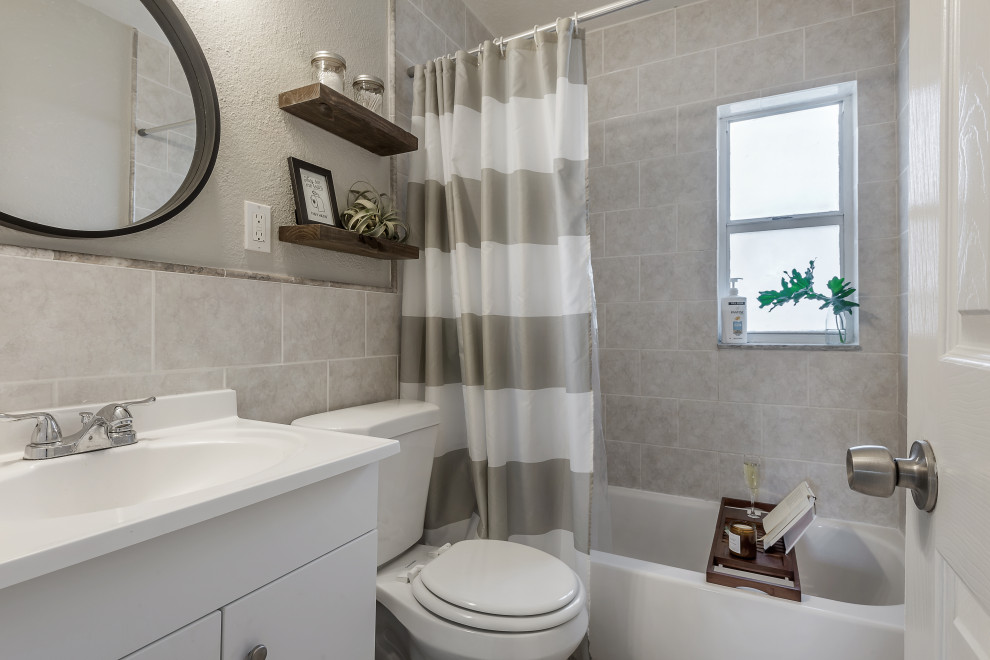 На фото: маленькая ванная комната в стиле фьюжн с белыми фасадами, накладной ванной, душем над ванной, бежевой плиткой, керамической плиткой, серыми стенами, полом из керамической плитки, бежевым полом и шторкой для ванной для на участке и в саду