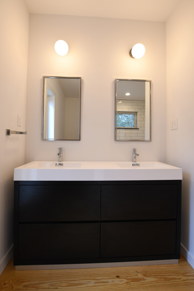 Design ideas for a medium sized midcentury ensuite bathroom in New York with flat-panel cabinets, black cabinets, an alcove bath, an alcove shower, a one-piece toilet, white walls, light hardwood flooring, an integrated sink, solid surface worktops, brown floors, an open shower, white worktops, double sinks and a freestanding vanity unit.