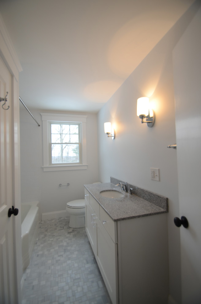 This is an example of a small contemporary bathroom in Boston with an integrated sink, flat-panel cabinets, white cabinets, granite worktops, an alcove bath, a shower/bath combination, a one-piece toilet, grey tiles, ceramic tiles, white walls and ceramic flooring.