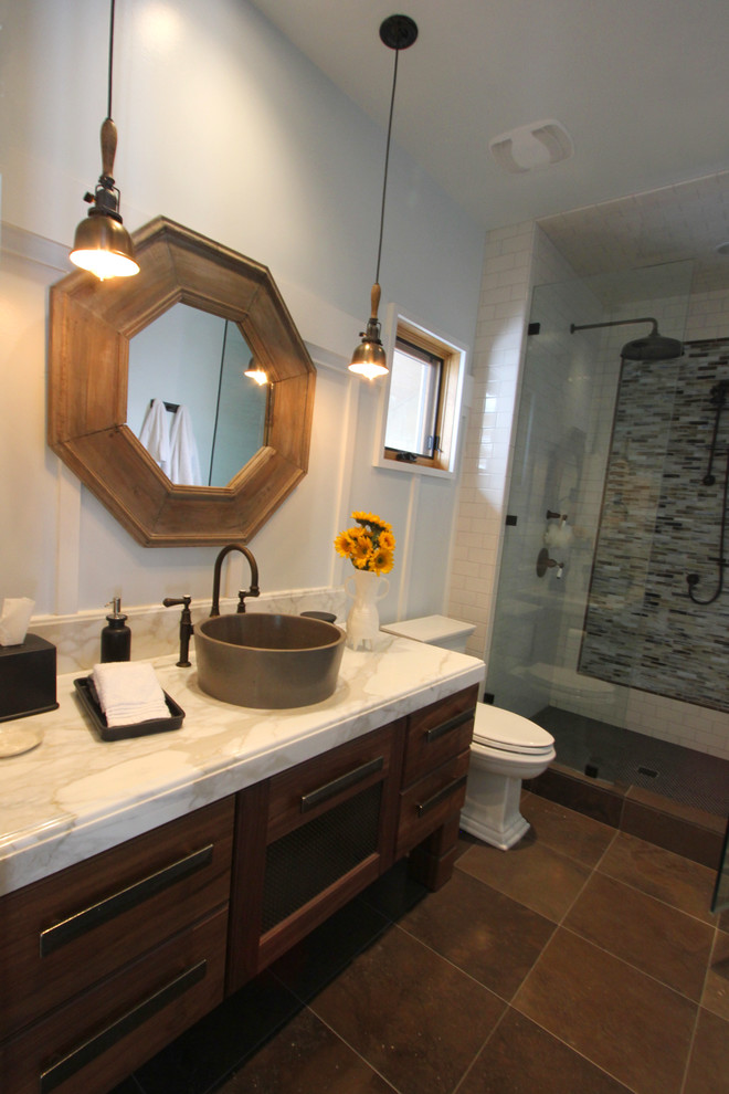 Example of a mid-sized cottage white tile and subway tile limestone floor alcove shower design in Salt Lake City with a vessel sink, furniture-like cabinets, medium tone wood cabinets, marble countertops, a two-piece toilet and white walls