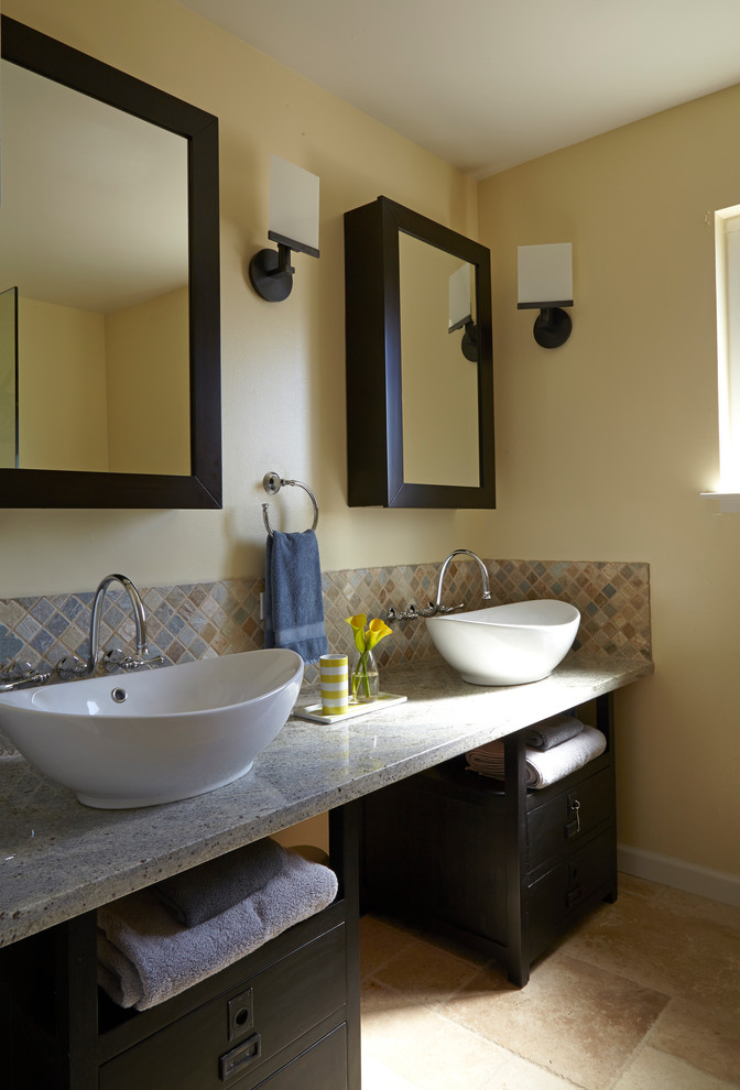Exemple d'une grande salle de bain principale tendance avec un placard en trompe-l'oeil, des portes de placard noires, un carrelage de pierre, un mur beige, un sol en travertin, une vasque et un plan de toilette en granite.