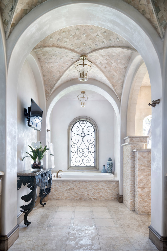 Idee per una stanza da bagno mediterranea con vasca da incasso, piastrelle beige e pareti bianche