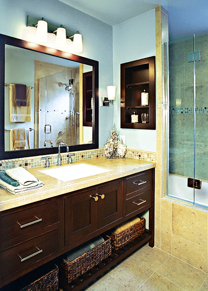 Esempio di una piccola stanza da bagno padronale classica con lavabo sottopiano, ante lisce, ante in legno bruno, top in marmo, vasca ad alcova, vasca/doccia, piastrelle beige, piastrelle in pietra, pareti blu e pavimento in marmo