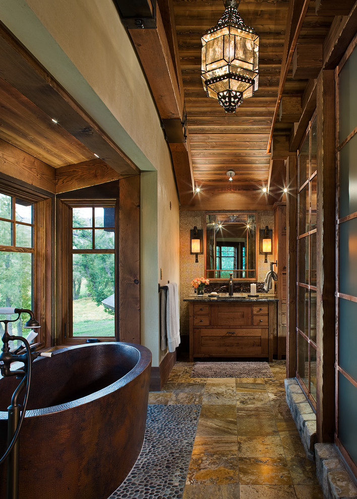 Idéer för stora rustika en-suite badrum, med ett undermonterad handfat, skåp i mellenmörkt trä, granitbänkskiva, ett fristående badkar, beige väggar, travertin golv och skåp i shakerstil