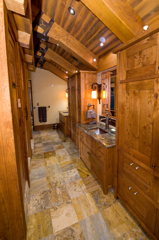 Inspiration pour une grande salle de bain principale chalet en bois brun avec un lavabo encastré, un placard en trompe-l'oeil, un plan de toilette en granite, un mur beige et un sol en travertin.