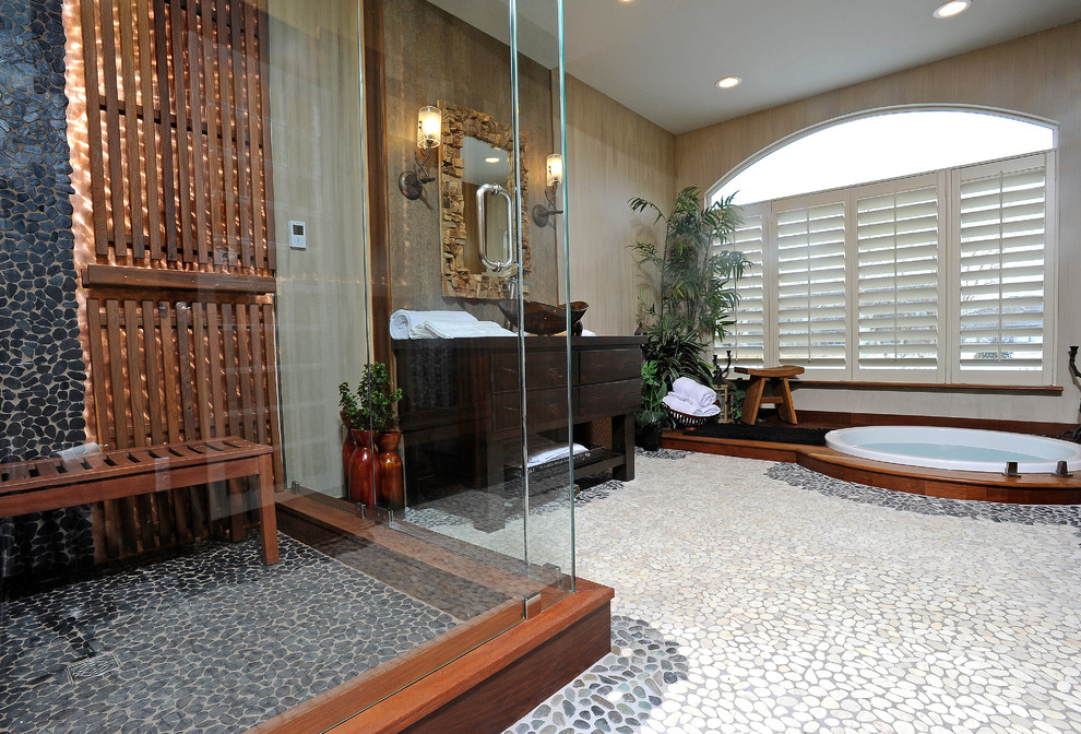 На фото: баня и сауна среднего размера в восточном стиле с настольной раковиной, плоскими фасадами, искусственно-состаренными фасадами, столешницей из дерева, инсталляцией, разноцветной плиткой, каменной плиткой, разноцветными стенами, полом из галечной плитки, японской ванной и угловым душем с
