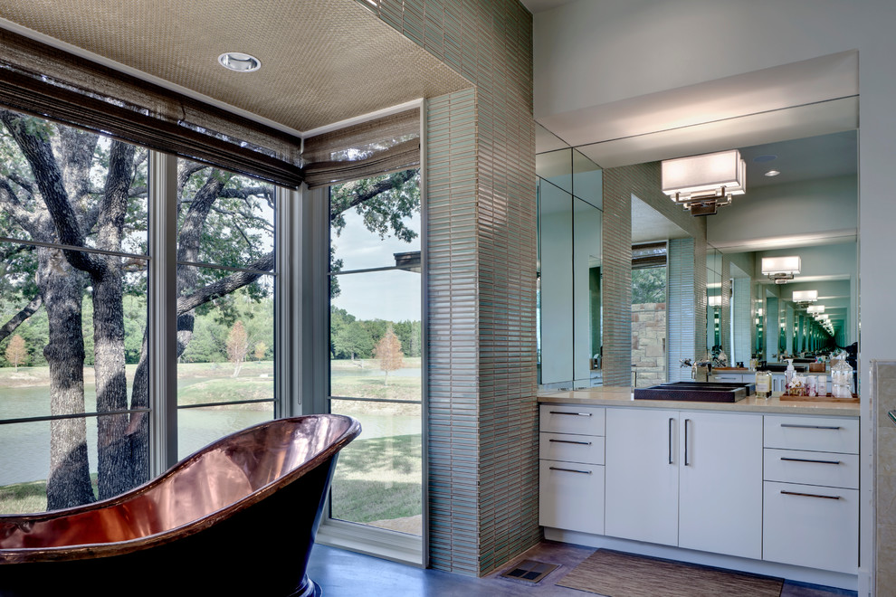 На фото: ванная комната в современном стиле с плоскими фасадами, белыми фасадами, отдельно стоящей ванной, синей плиткой, белыми стенами и накладной раковиной