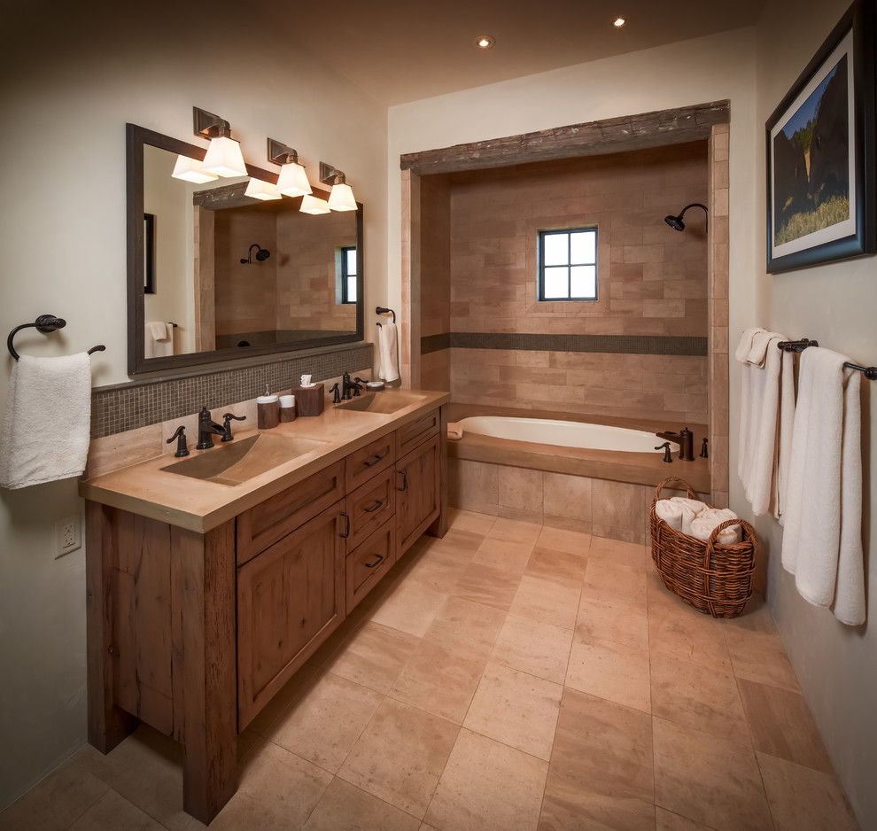 На фото: ванная комната в стиле рустика с монолитной раковиной, ванной в нише, бежевой плиткой и столешницей из бетона